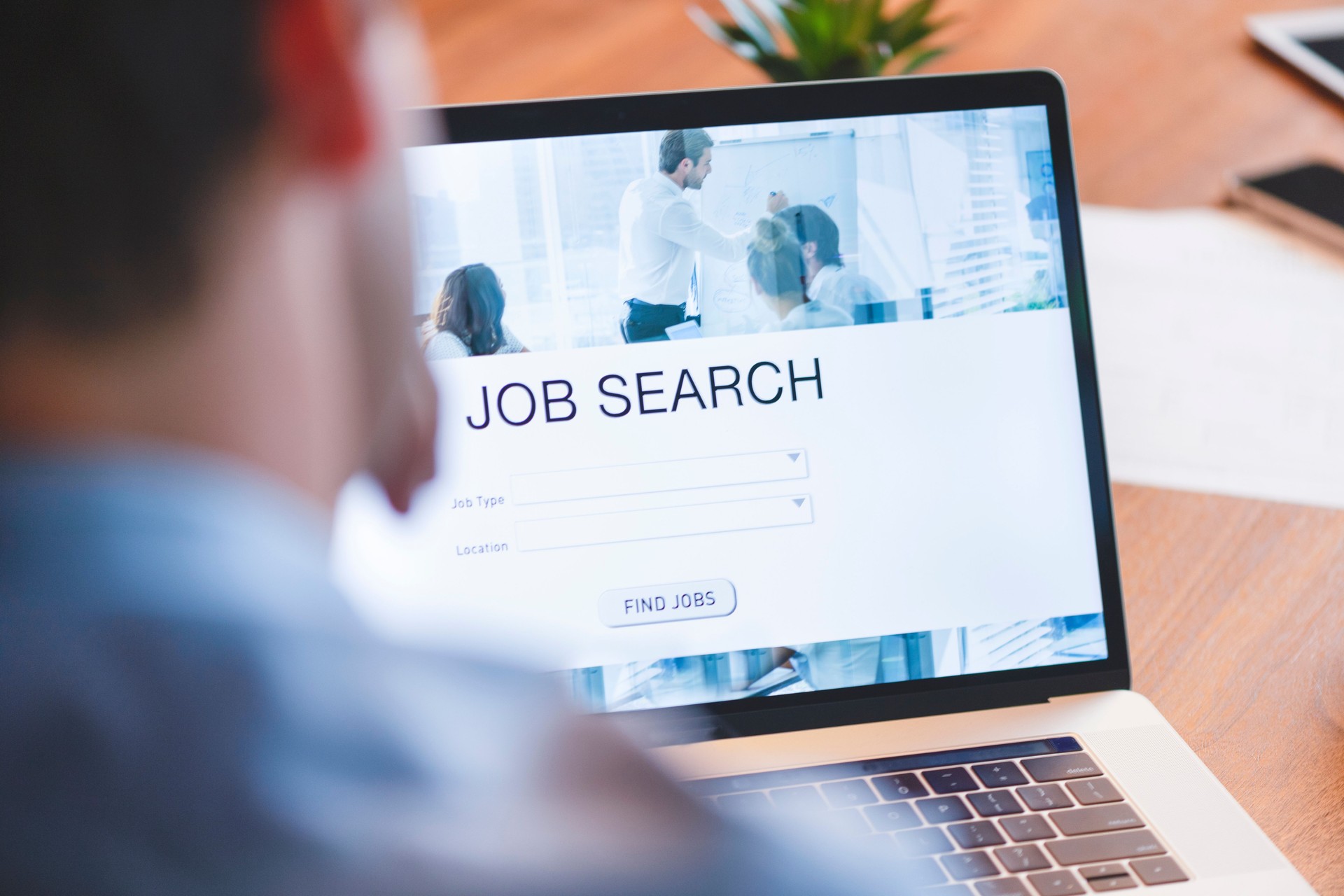 Businessman looking at job search website on a laptop computer.